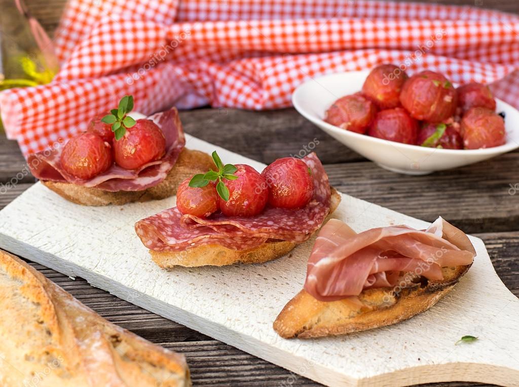 Italian antipasti bruschettas with ham prosciutto, coppa, salami Stock