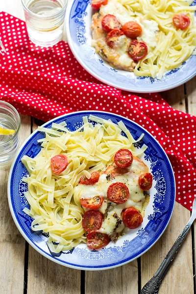 Chicken breasts with cherry tomatoes, mozzarella and pasta — Stock Photo, Image
