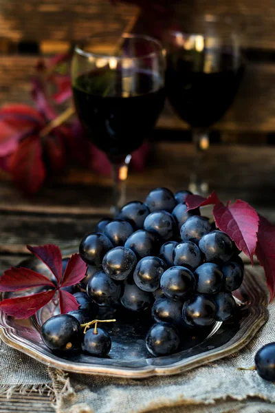 Black table grapes on plate with black wine — Stock Photo, Image