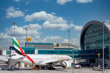 DUBAI, BAE - CIRCA 2021: Emirates Havayolları uçakları Dubai Havalimanı 'nda bulutlu arka planda.