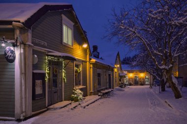 Porvoo 'da kış akşamı, eski şehrin sokaklarında eski ahşap evler. 