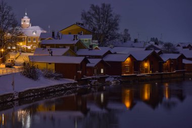Eski Porvoo 'da kış akşamı. Sudaki tarihi ahşap evlerin bulanık yansımalarıyla.. 