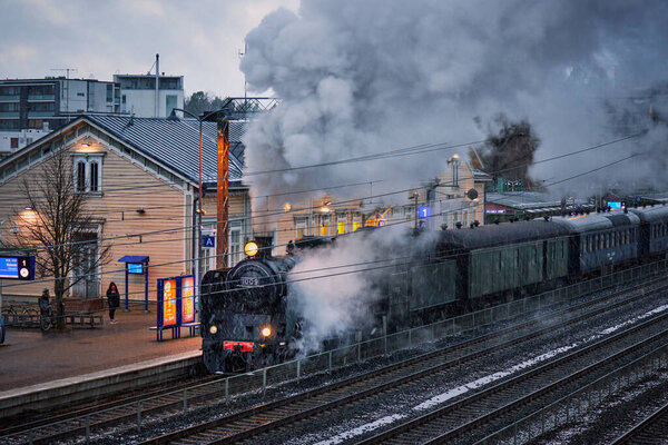 Finland, Kerava - 20 November 2020. Arrival of the old train at the old station in the snow.