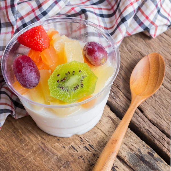 Ensalada de frutas con leche sobre madera — Foto de Stock