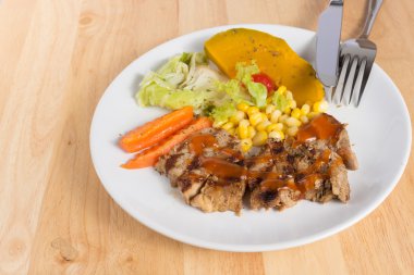 Ahşap masa üzerinde domuz eti biftek