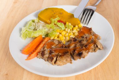 Ahşap masa üzerinde domuz eti biftek