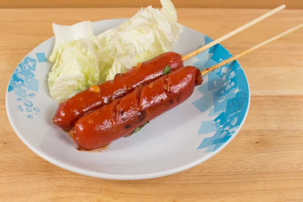 Salsicha com molho picante no prato — Fotografia de Stock