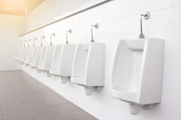 Lijn van wit porselein urinoirs in de openbare toiletten — Stockfoto