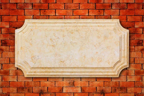 Uma placa de mármore na parede de tijolo . — Fotografia de Stock
