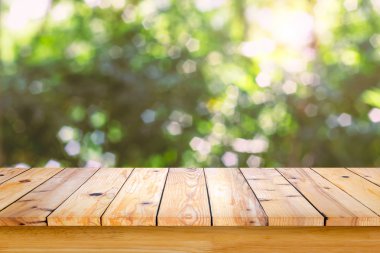 Bokeh soyut yeşil arka plana sahip boş ahşap masa.