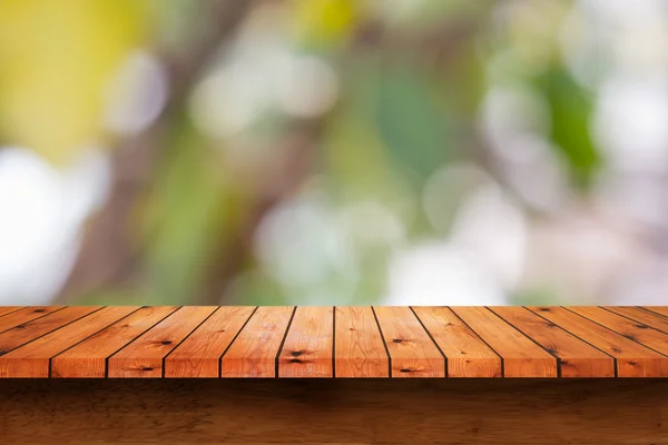 Üres fából készült asztal homályos zöld háttér. — Stock Fotó