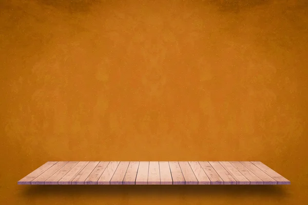 グランジのオレンジ色の壁の背景に木製の棚. — ストック写真