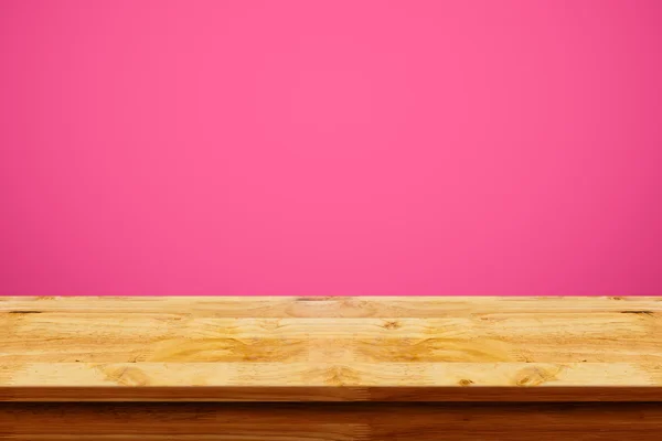 Lege top van houten tafel op roze achtergrond. — Stockfoto