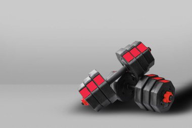 Spor salonunda yerde siyah halterler..