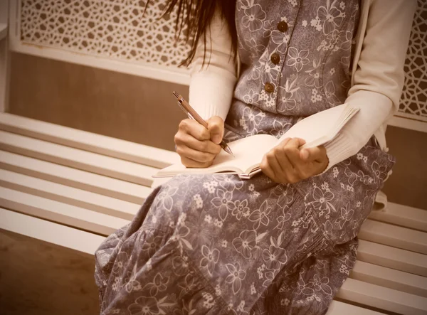 Молодая девушка пишет в свой дневник — стоковое фото