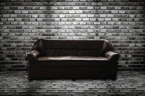 Sofá de cuero en habitación de ladrillo — Foto de Stock