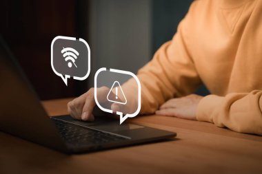 Wi-Fi ve uyarı simgeleri olmayan dizüstü bilgisayar kullanan kişi, bağlantı arızasını, ağ hatasını, internet kesintisini, ağ arızasını, çevrimdışı modu ve teknolojik bozulmayı temsil ediyor.