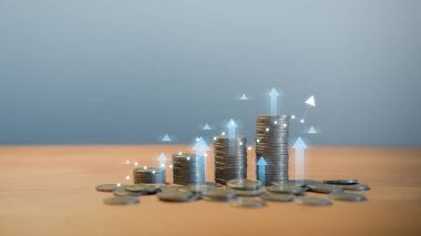 Parlak okları ve grafik çizgisi olan bozuk para yığınları, finansal büyümeyi, yatırım başarısını, iş kârındaki artışı, ekonomik büyümeyi ve modern finans sektöründeki zenginliği sembolize ediyor.