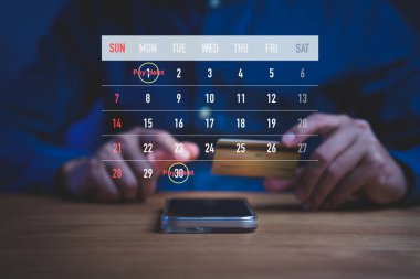 Finansal planlama kavramı, kredi kartında dijital takvim bulunan kişinin ödeme borçları, fatura hatırlatmaları, borç yönetimi ve kişisel finans programlarını sembolize ettiğini gösteriyor..