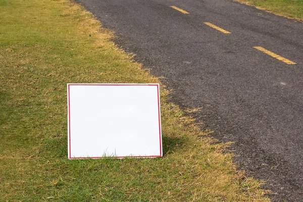 White board sign on grass — Stock Photo, Image