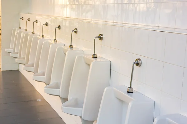 Linie z bílého porcelánu pisoárů na veřejných toaletách — Stock fotografie