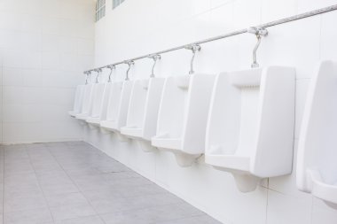 Genel tuvaletler içinde beyaz porselen pisuar hattı