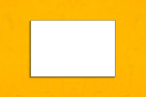 Cartaz de papel dobrado em branco pendurado na parede amarela — Fotografia de Stock