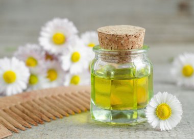 Küçük şişe kozmetik papatya yağı ve ahşap saç tarağı 