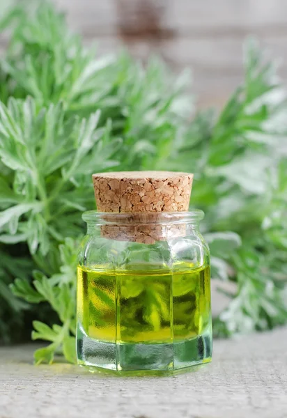 Small bottle of cosmetic oil with natural (herbal) extracts — Stock Photo, Image