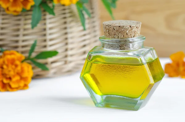 Small bottle of cosmetic oil with marigold flowers extract (tincture, infusion) — Stock Photo, Image