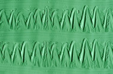 Yeşil kozmetik kil (yosun maskesi, yüz kremi, spirulina vücut ambalajı) dokusu yakın, seçici odaklanma. Fırça darbeleriyle soyut arkaplan.