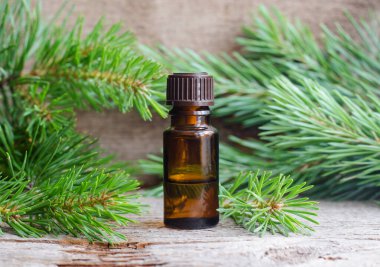 Temel çam yağı içeren küçük bir şişe (özü, tütsü, zerk). Eski ahşap arka plan. Aromaterapi, spa ve bitkisel tıp konsepti. Boşluğu kopyala. 