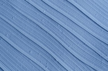 Açık mavi bentonit yüz kilini (aljinat maskesi, yüz kremi, vücut sargısı) kapat, seçici odaklanma. Fırça darbeleriyle soyut arkaplan. 