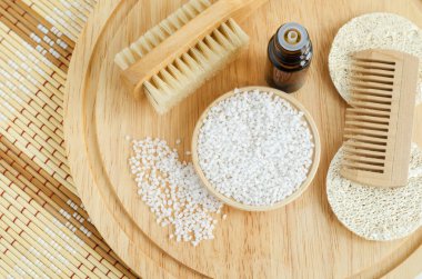 Beyaz epsom banyo tuzlu küçük tabak (ayak ıslatma), tahta saç ve masaj vücut fırçası. Çevre dostu tuvalet malzemeleri. Doğal güzellik tedavisi, cilt bakımı veya sıfır atık konsepti. Üst görünüm, alanı kopyala. 