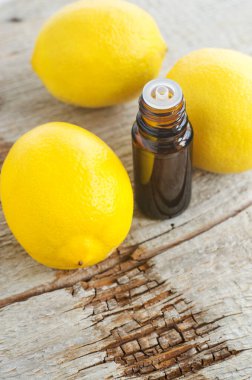 İçinde limon yağı bulunan küçük şişe (özü, tütsü, zerk, parfüm). Aromaterapi, spa ve bitkisel ilaç malzemeleri. Eski ahşap arka plan. Boşluğu kopyala 