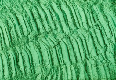 Yeşil kozmetik kil tozu (yosun maskesi, spiulina vücut ambalajı) dokusu yakın, seçici odaklanma. Fırça darbeleriyle soyut arkaplan. 