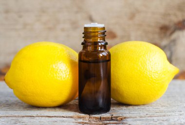 İçinde limon yağı bulunan küçük şişe (özü, tütsü, zerk, parfüm). Aromaterapi, spa ve bitkisel ilaç malzemeleri. Eski ahşap arka plan. Boşluğu kopyala 