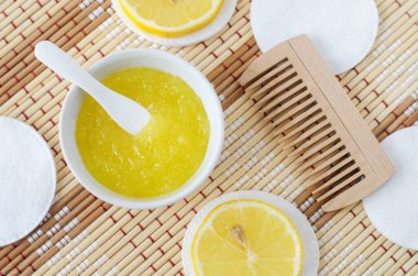 Ev yapımı limonlu meyve fırçası (banyo tuzu, ayak tuzu, yüz veya saç maskesi) küçük beyaz bir kasede. Doğal güzellik tedavisi, saç bakımı ve spa tarifi. Üst görünüm, alanı kopyala. 