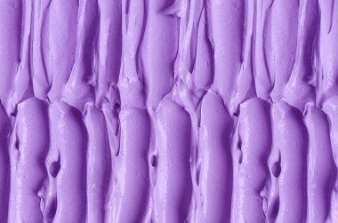 Mor kil (aljinat yüz maskesi, vücut ambalajı, saç kremi) dokusu yakın, seçici odaklanma. Fırça leylekleri ile soyut lavanta arkaplanı.