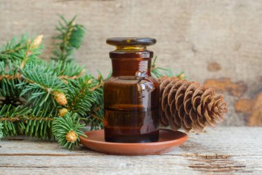 Temel köknar yağı içeren eczacı şişesi (özet, tentür, infüzyon). Eski ahşap arka plan. Aromaterapi, spa ve bitkisel tıp konsepti. Boşluğu kopyala. 