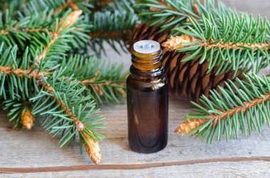 Temel köknar yağı içeren küçük şişe (özet, tentür, infüzyon). Eski ahşap arka plan. Aromaterapi, spa ve bitkisel tıp konsepti. Boşluğu kopyala. 