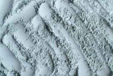 Gri, mavi bentonit kil tozu (aljinat, yüz maskesi, göz farı, vücut ambalajı) dokusu yakın, seçici odaklanma. Soyut arkaplan. 