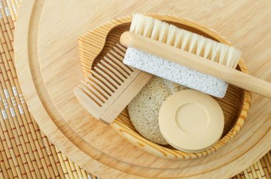 Bir kalıp sabun (sağlam şampuan), tahta saç fırçası ve sünger taşlı ayak fırçası. Çevre dostu tuvalet malzemeleri hazır. Doğal güzellik tedavisi, cilt bakımı veya sıfır atık konsepti. Üst görünüm, alanı kopyala. 