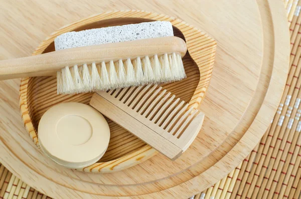 Bar of soap (solid shampoo), wooden hair brush and foot brush with pumice stone. Eco friendly toiletries set. Natural beauty treatment, skin care or zero waste concept. Top view, copy space.
