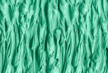 Yeşil kozmetik kil (yosun maskesi, yüz kremi, spirulina vücut ambalajı) dokusu yakın, seçici odaklanma. Fırça darbeleriyle soyut arkaplan.
