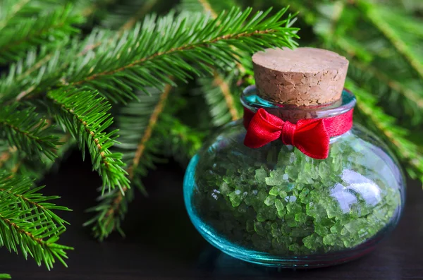 Botella pequeña de sal de baño y ramas de árbol de Navidad —  Fotos de Stock