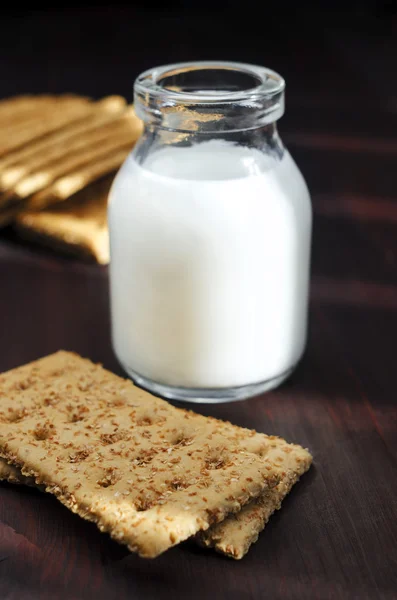 Biscoitos orgânicos com farelo e pequena garrafa de leite — Fotografia de Stock