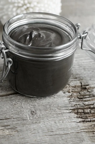 Black volcanic cosmetic clay in a glass jar — Stock Photo, Image