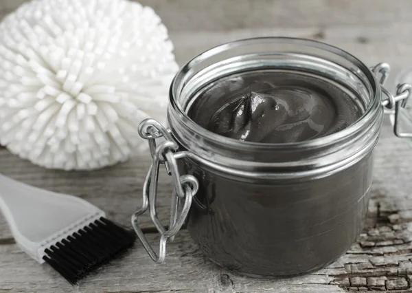 Black volcanic cosmetic clay in a glass jar — Stock Photo, Image
