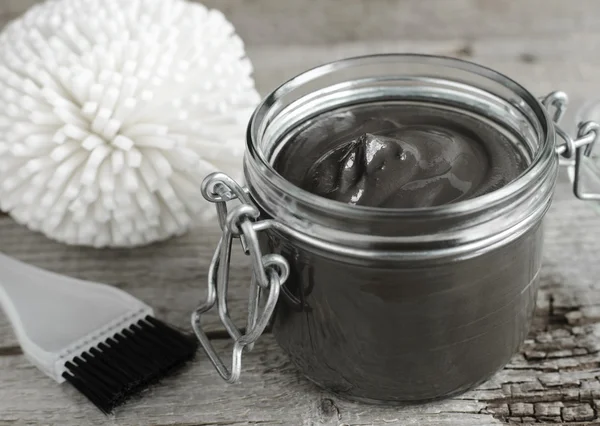 Black volcanic cosmetic clay in a glass jar